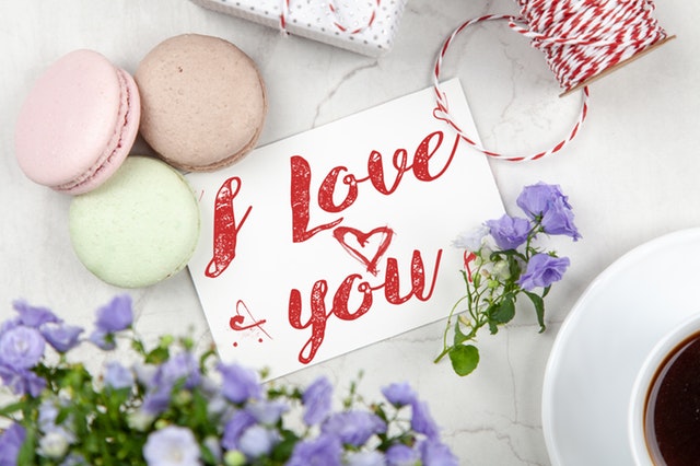 a romantic gesture of a note that says I love you next to some cookies